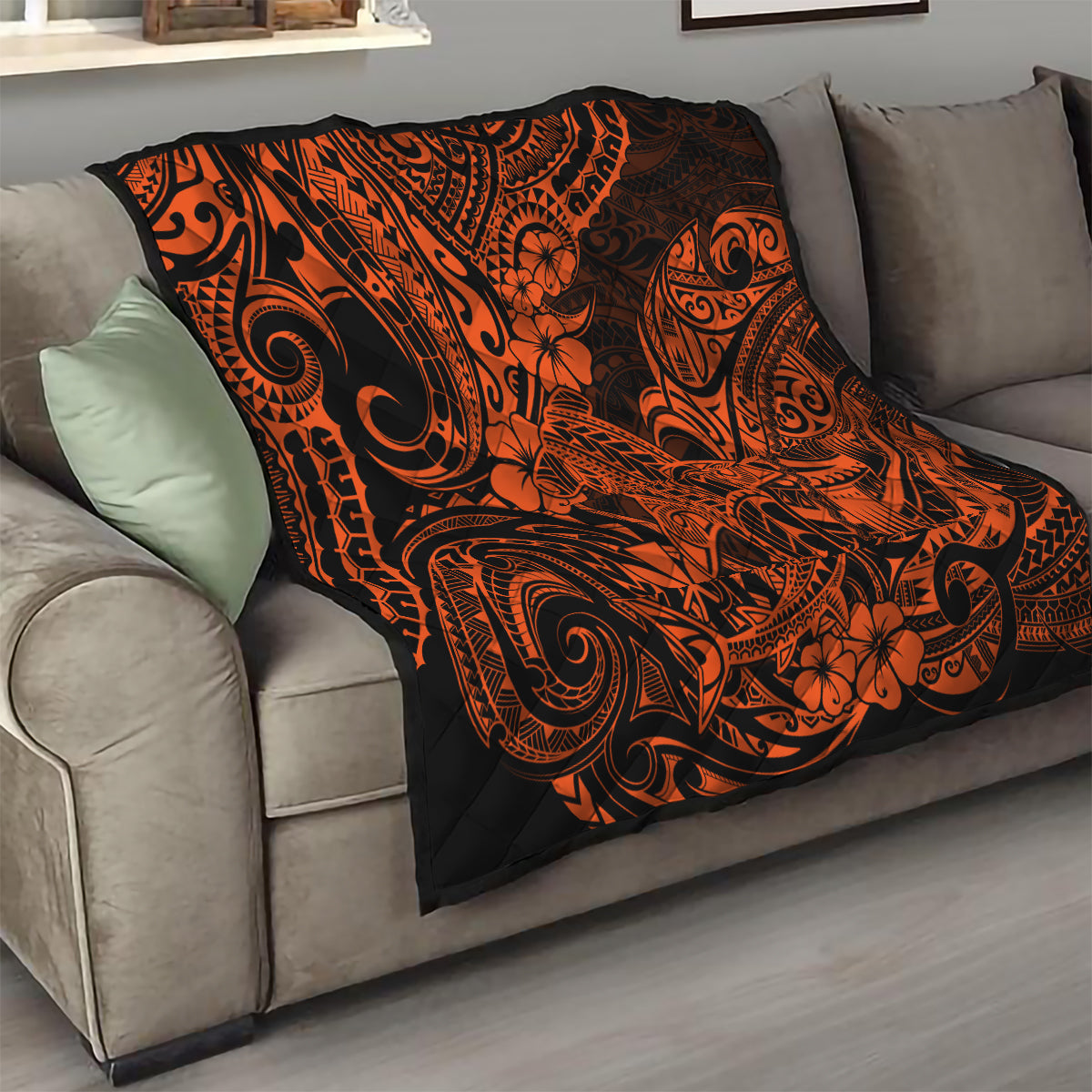Orange and black Polynesian-style quilt over a sofa, bold tribal swirls and floral motifs