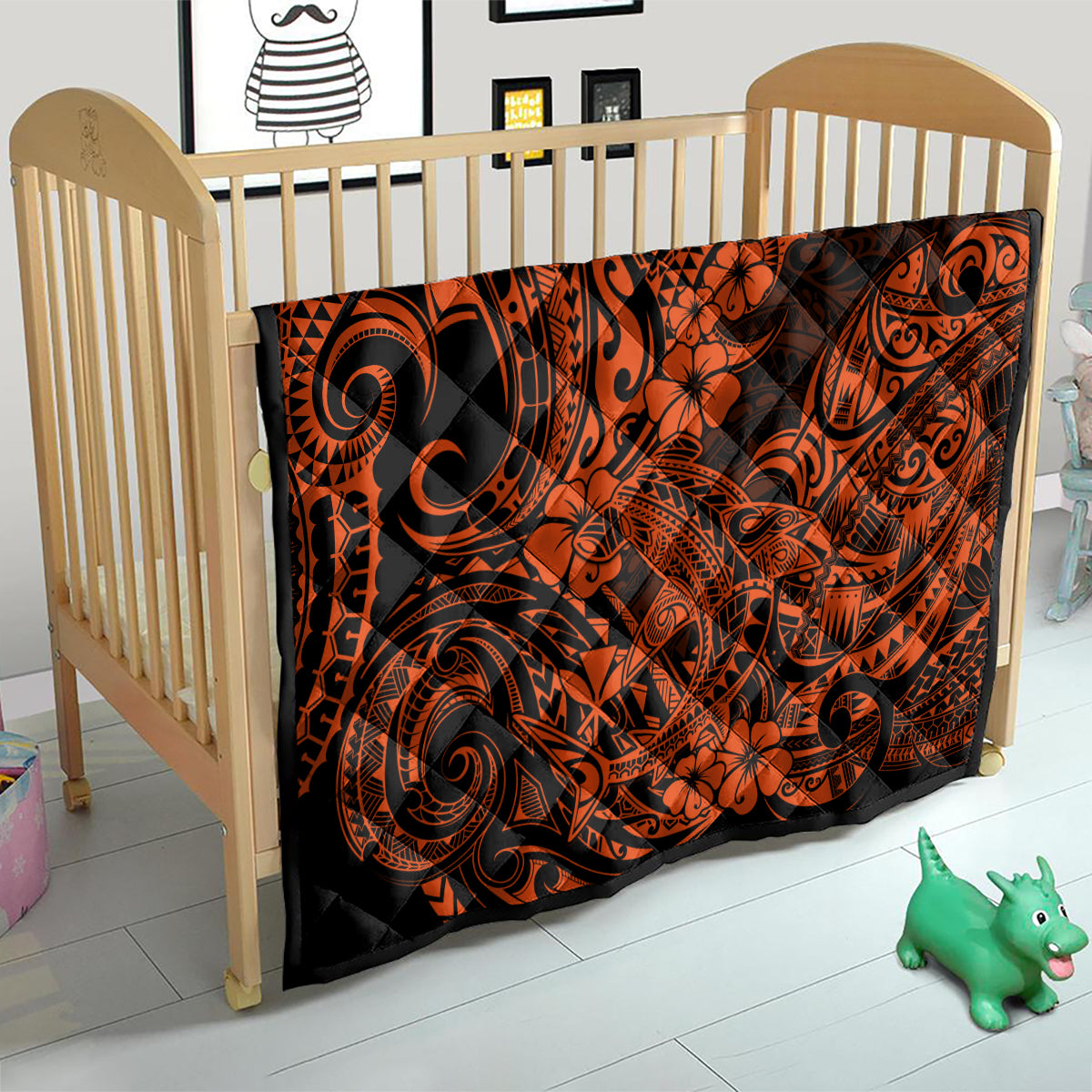 Orange and black Polynesian-style quilt over a crib mattress, swirling tribal and flowers