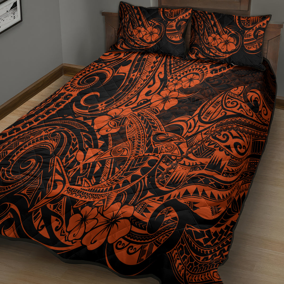 Orange and black Polynesian pattern quilt and pillow shams on bed, angled view