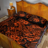 Orange and black patterned quilt with two pillow shams on wooden bed frame