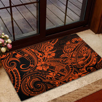 Orange and black polynesian patterned rubber doormat near an entry step.