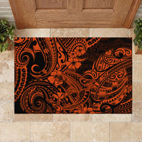 Orange and black polynesian patterned rubber doormat under a wooden door.