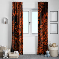 Pair of orange and black Polynesian pattern curtains hanging on a window frame