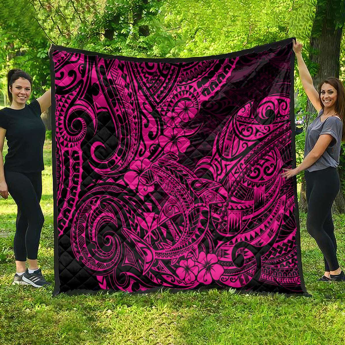 Pink and black Polynesian shark pattern quilt blanket, spread outdoors