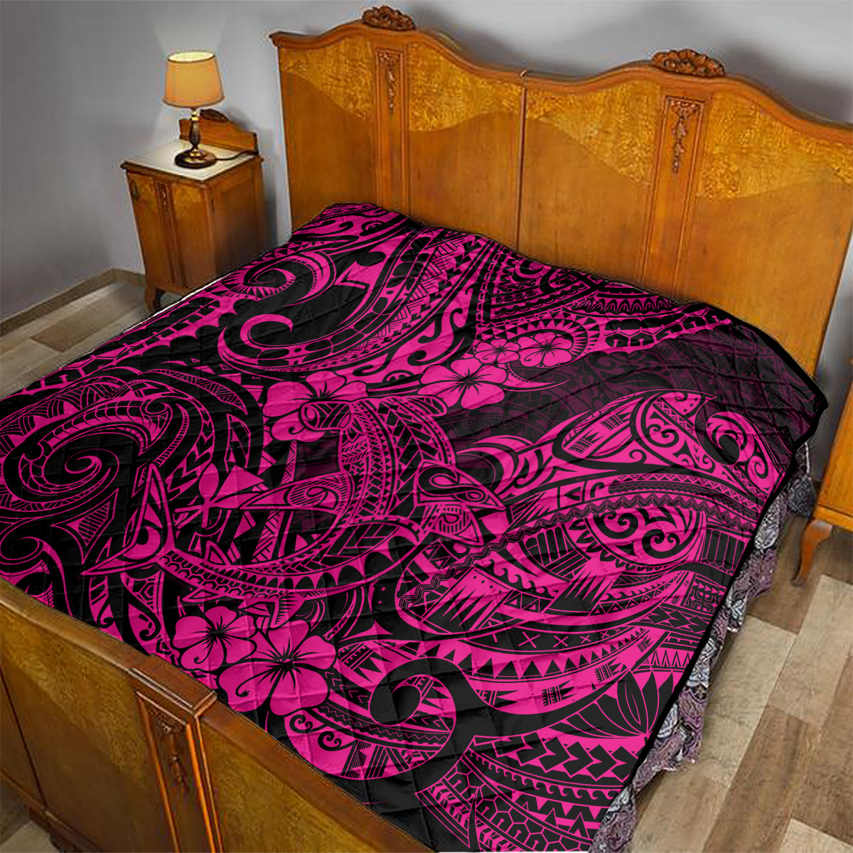 Pink and black Polynesian shark pattern quilt on a bed