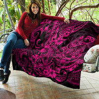 Pink and black Polynesian shark pattern quilt blanket held on a couch