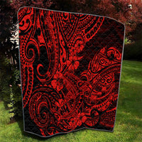Red and black Polynesian shark pattern quilt, square blanket draped on grass.