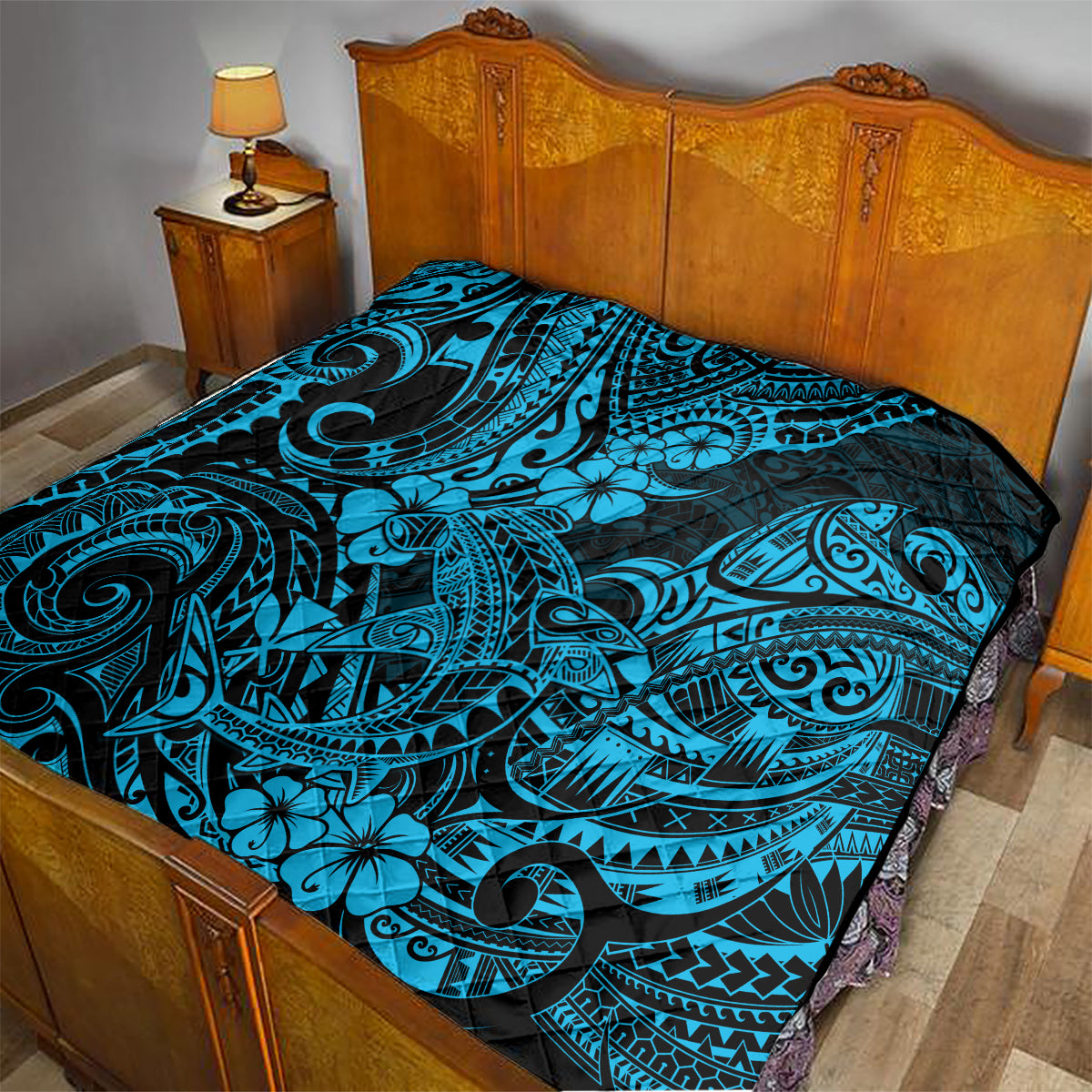 Polynesian shark quilt on bed, black base with turquoise tiki shark pattern and hibiscus