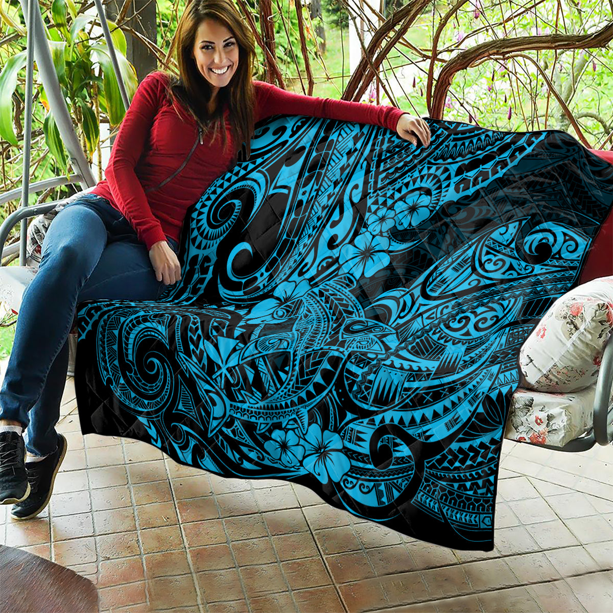 Polynesian shark quilt draped on couch, black base with turquoise shark tribal and floral print