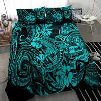 Turquoise Polynesian print comforter and pillowcases on a bed, close-up view