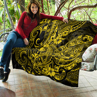 Yellow and black Polynesian shark quilt with bold swirling motifs, laid on patio seating