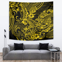 Yellow and dark Polynesian pattern tapestry on wall above gray couch