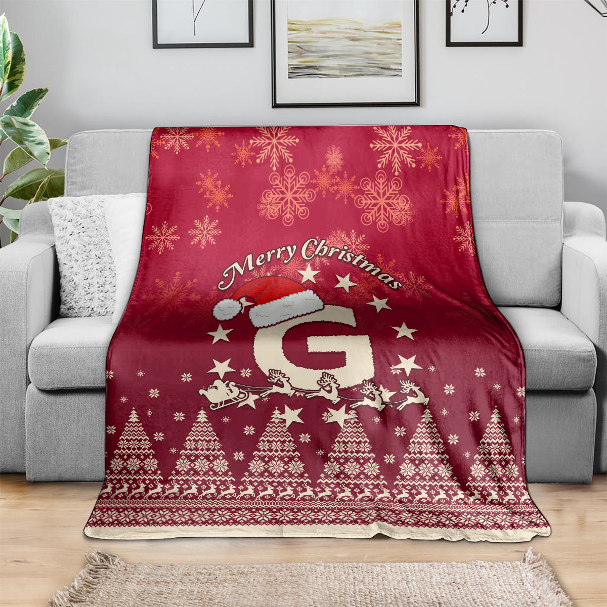 Red Christmas blanket draped on sofa with Santa riding reindeer, snowflakes and trees