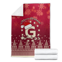 Folded red Christmas blanket with Santa riding reindeer, snowflakes, stars, and holiday border