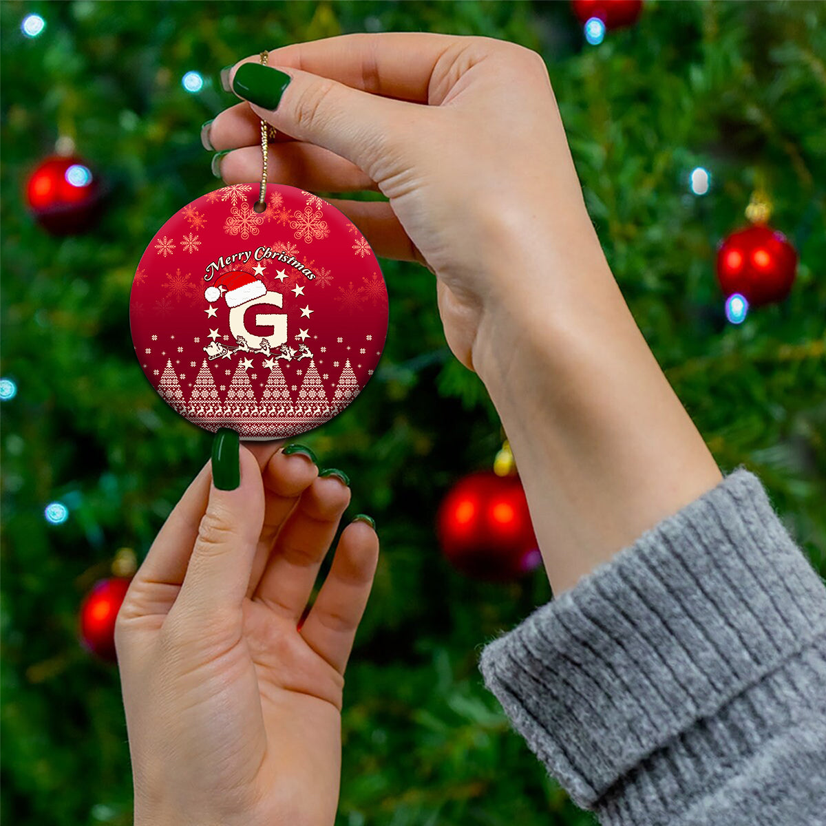 Red ceramic round Christmas ornament with Santa riding reindeer and letter G, gold hanging string