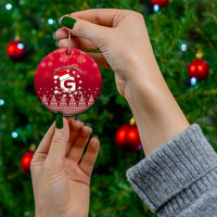 Red ceramic round Christmas ornament with Santa riding reindeer and letter G, gold hanging string