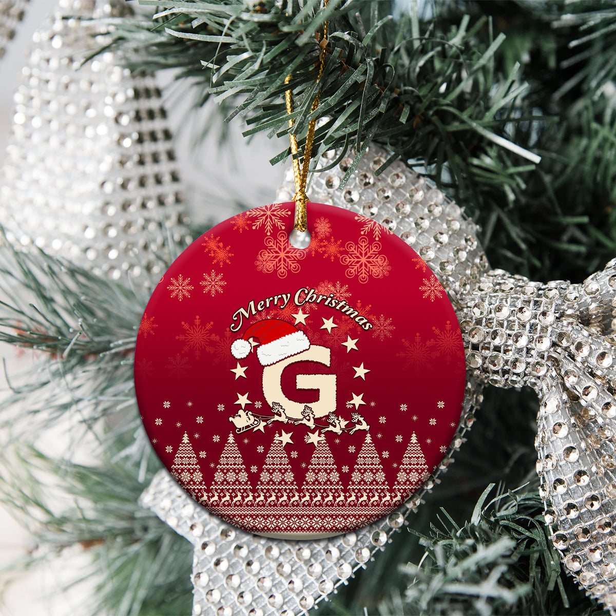 Red ceramic round Christmas ornament showing Santa riding reindeer and letter G, “Merry Christmas”