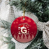 Red ceramic round Christmas ornament showing Santa riding reindeer and letter G, “Merry Christmas”