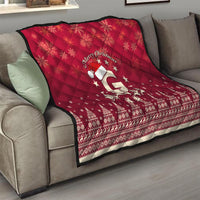 Red quilt throw on living room sofa with “Merry Christmas” and Santa riding reindeer