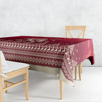 Red Christmas tablecloth draped over table with patterned edge and snowflake motifs