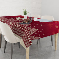 Red Christmas tablecloth with reindeer and snowflake pattern, laid across dining table