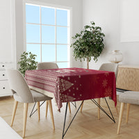 Red Christmas tablecloth with patterned border and snowflake motifs on dining set