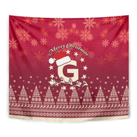 Red Christmas tapestry close-up with “Merry Christmas” text, Santa hat, stars, and pine trees