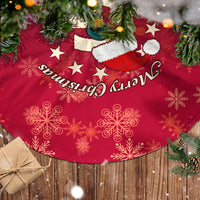 Red Christmas tree skirt with snowflakes, stars, and Merry Christmas script