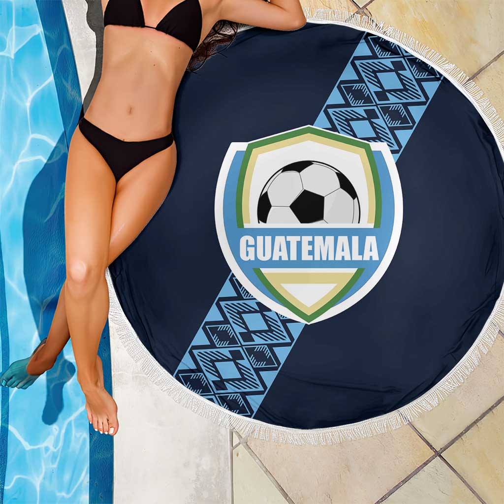 Round navy beach blanket with white fringe and Guatemala crest soccer-ball graphic by poolside