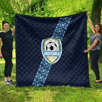 Navy football quilt spread outdoors, diamond quilting and Guatemala crest on diagonal stripe