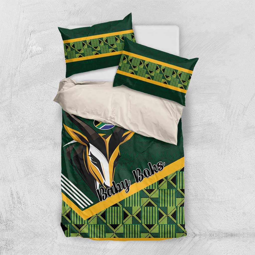 Flat-lay view of green baby bedding set with rugby emblem and yellow-trim pillowcases