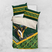 Flat-lay view of green baby bedding set with rugby emblem and yellow-trim pillowcases