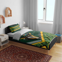 Green baby bedding set on bed with rugby logo, yellow accents, and geometric plaid design
