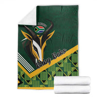 Green baby blanket with 'Baby Boks' rugby shield, folded with white towels