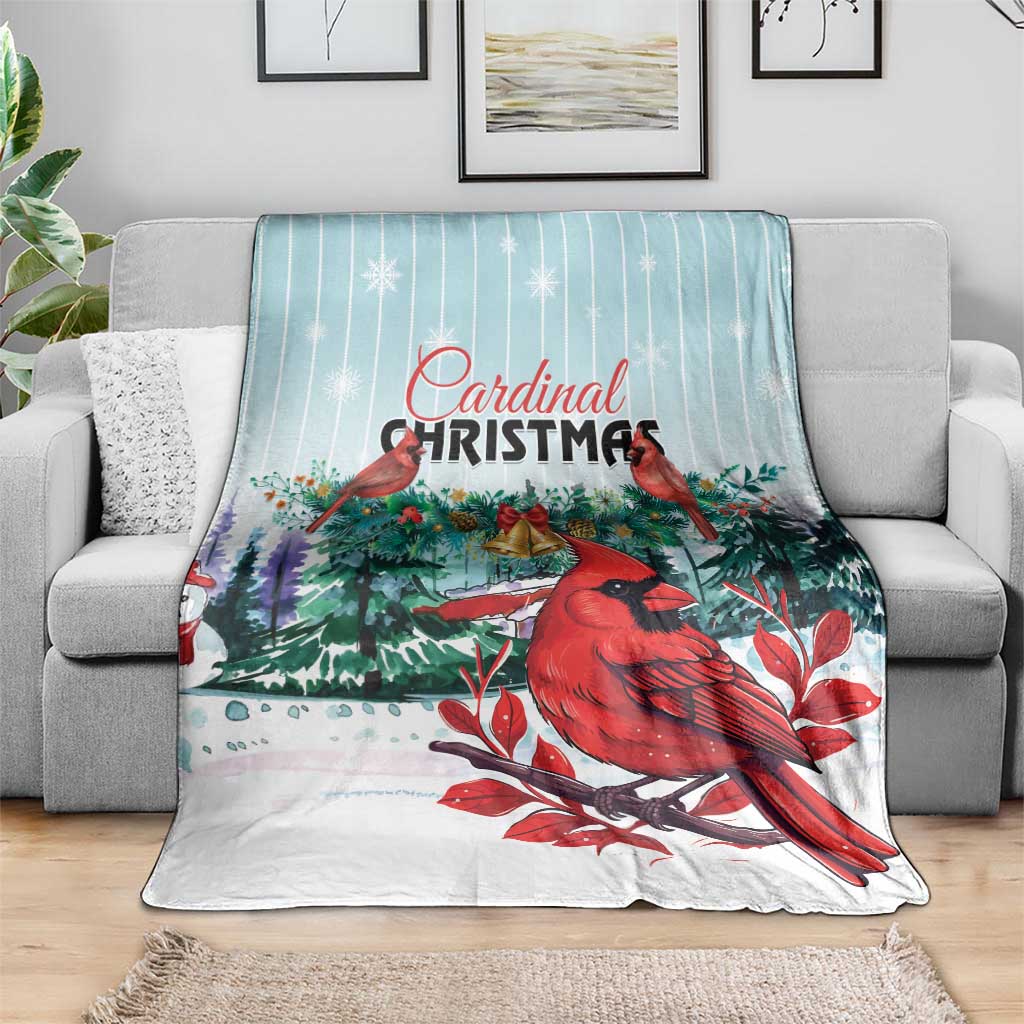 Cardinal Christmas blanket draped on sofa, featuring red birds and evergreen holiday greenery.