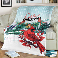 Cardinal Christmas blanket on armchair showing large red cardinal artwork with green foliage.