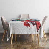 Mint Christmas tablecloth with red cardinal and pine scene across tabletop