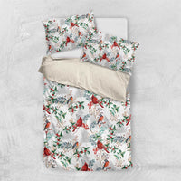 White bedding set laid flat: duvet and pillowcases with red cardinal and green foliage
