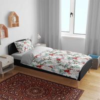 White bedding set on bed frame with red cardinal bird and green foliage repeat pattern