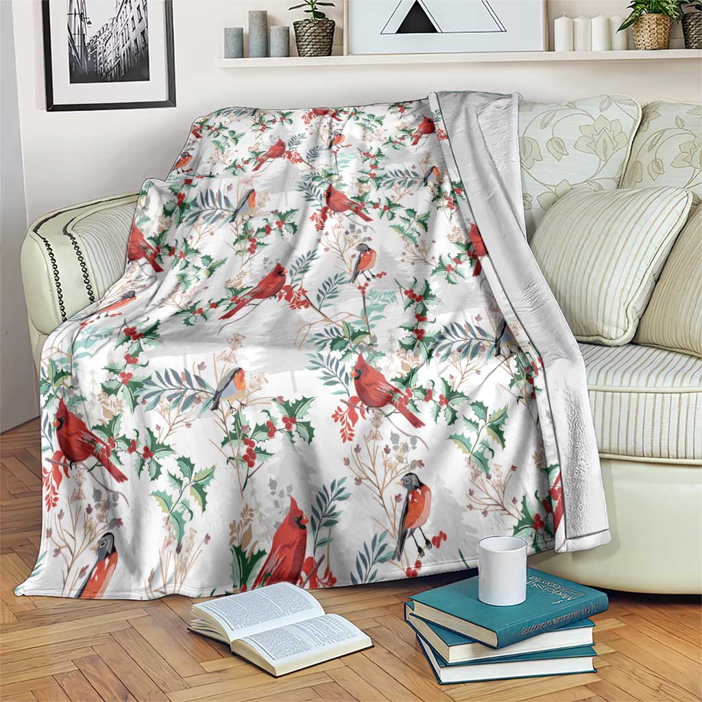 Christmas blanket in white with red cardinal birds and green leaf pattern, draped on sofa