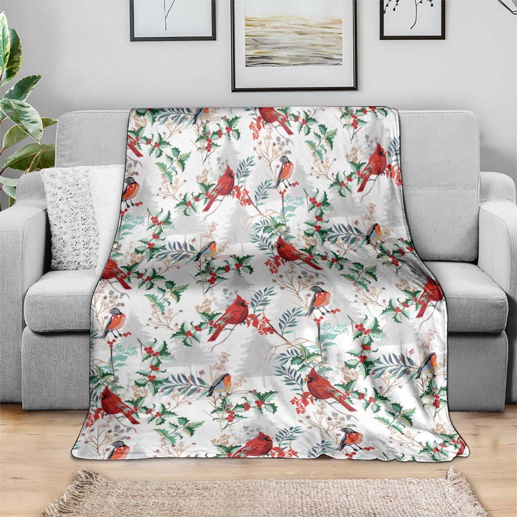Christmas blanket with red cardinals and green leaves on a white background, on gray couch