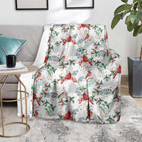 Christmas blanket with cardinal bird and greenery print, draped on light rug