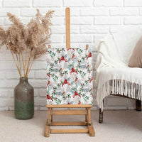 Christmas cardinal canvas wall art shown upright on a wooden stand with botanical pattern