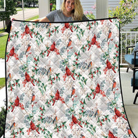 White quilt with red cardinal and green leaf pattern, diamond stitched quilting border