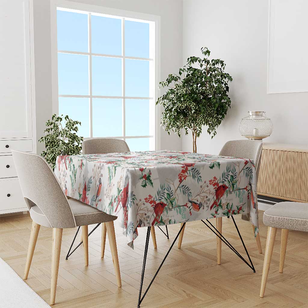 White tablecloth with red birds and green leaf pattern, draped over dining table