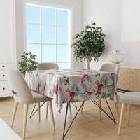 White tablecloth with red birds and green leaf pattern, draped over dining table