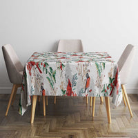 White Christmas tablecloth with red cardinals and green foliage, over dining table
