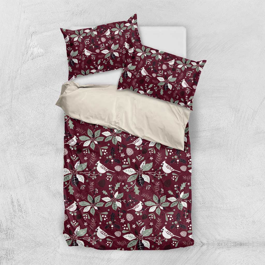 Deep red bedding set flat lay with white poinsettia and bird pattern duvet and pillowcases