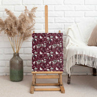 Wine red canvas wall art displayed upright on a wooden easel with holiday bird pattern