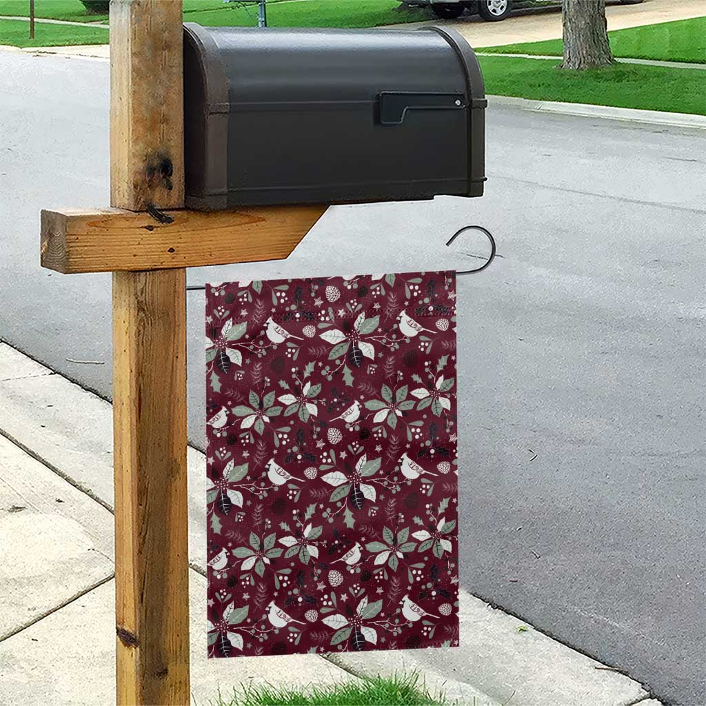 Wine red garden flag hanging from a wooden post with white poinsettias and birds
